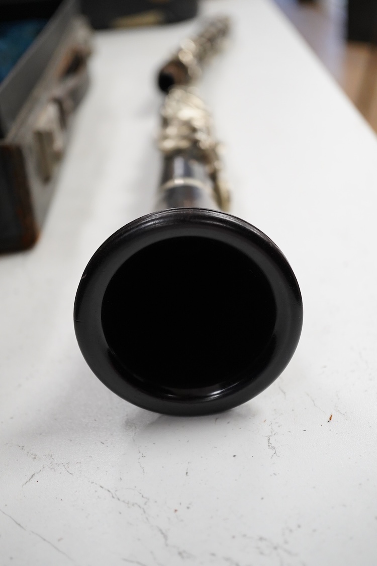 An early 20th century wooden Boosey and Hawkes clarinet in a fitted leather case
